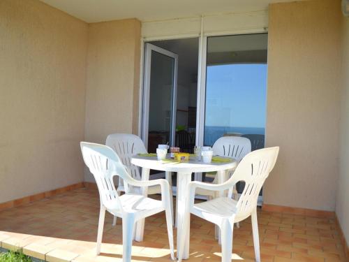 - une table et des chaises blanches sur la terrasse dans l'établissement Appartement 2 pièces avec terrasse, WIFI et parking à Banyuls-sur-Mer - FR-1-225C-488, à Banyuls-sur-Mer