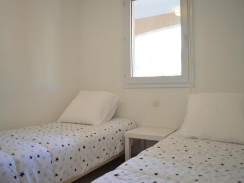 une chambre avec deux lits et une fenêtre dans l'établissement Appartement 2 pièces avec terrasse, WIFI et parking à Banyuls-sur-Mer - FR-1-225C-488, à Banyuls-sur-Mer