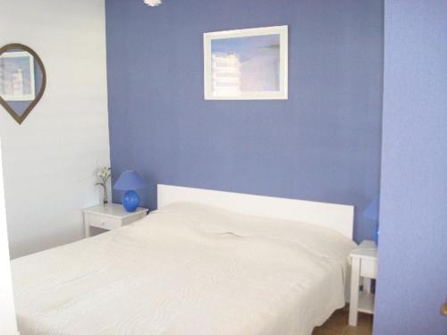 a bedroom with a white bed and a blue wall at Appartement Vieux-Boucau-les-Bains, 2 pièces, 5 personnes - FR-1-379-38 in Vieux-Boucau-les-Bains