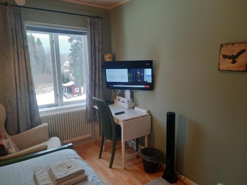 a room with a desk with a computer and a monitor at Geijersholms Herrgård in Hagfors