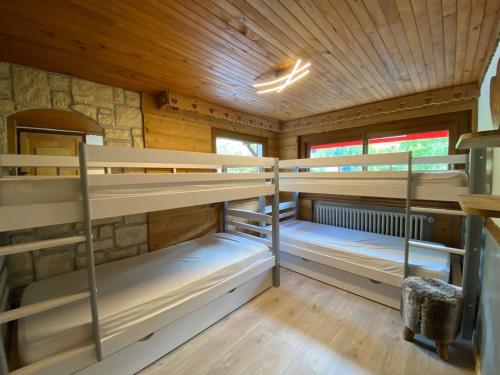 une chambre avec trois lits superposés dans une cabine dans l'établissement Appartement cosy 6 personnes avec grande terrasse et parking, près des activités - FR-1-241-181, au Grand-Bornand