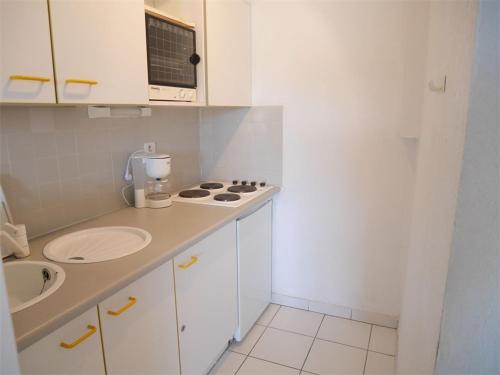 - une petite cuisine blanche avec un évier et un comptoir dans l'établissement Studio cabine à 150m plage avec parking privatif - Argelès-sur-Mer - FR-1-388-22, à Argelès-sur-Mer