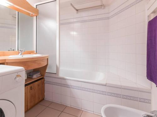 ein Badezimmer mit Badewanne und Waschbecken in der Unterkunft Appartement cosy avec balcon, parking privé et à 400m des télécabines – Centre-ville Briançon - FR-1-330C-19 in Briançon
