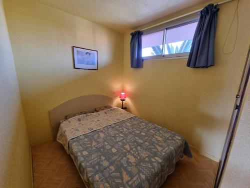 une petite chambre avec un lit et une fenêtre dans l'établissement Appartement lumineux T2 avec piscine, loggia et parking, 4 couchages - Argelès-sur-Mer - FR-1-388-55, à Argelès-sur-Mer
