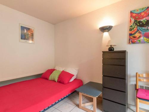 - une petite chambre avec un lit rouge et une commode dans l'établissement Charmant 2 pièces cabine avec balcon, proche télécabine et centre de Briançon - 4 pers. - FR-1-330C-24, à Briançon