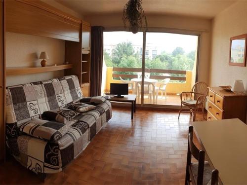 un salon avec un canapé et une table dans l'établissement Appartement T2 avec piscine et parking à 300m de la plage - FR-1-388-56, à Argelès-sur-Mer