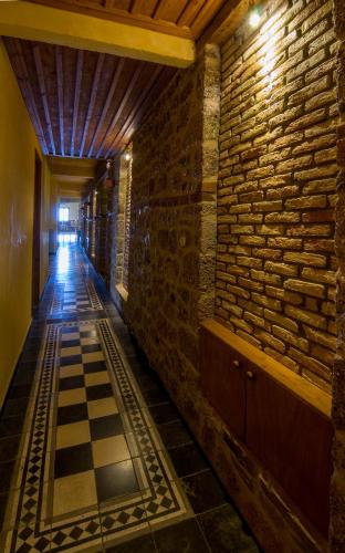 a hallway with a brick wall and a chessboard at Pigi Tarlampa Hotel in Ano Trikala