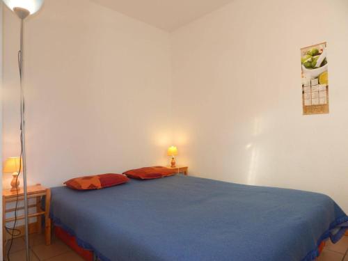 a bedroom with a blue bed with two orange pillows at Appartement Briançon, 2 pièces, 6 personnes - FR-1-330C-29 in Briançon
