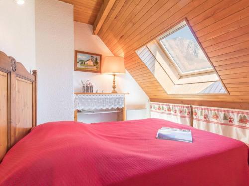 - une chambre avec un grand lit rouge et une lucarne dans l'établissement Appartement Briançon, 3 pièces, 6 personnes - FR-1-330C-30, à Briançon