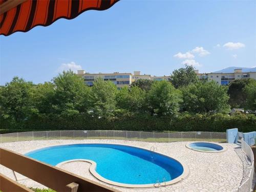 une grande piscine bleue installée sur un patio dans l'établissement Appartement T3 climatisé avec piscine, parking privé, proche plage - Argelès-sur-Mer - FR-1-388-128, à Argelès-sur-Mer