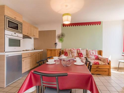 Il dispose d'une cuisine et d'un salon avec une table et des chaises rouges. dans l'établissement Appartement 2P, balcon sud, proche Prorel et centre, 4-6 pers., ski, 2 étoiles, Briançon - FR-1-330C-13, à Briançon