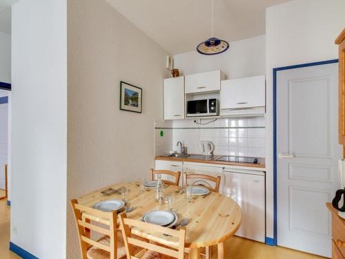 une petite cuisine avec une table et des chaises en bois dans l'établissement Appartement T2 à Cauterets avec Terrasse, Local à Ski, et Proche Télécabine - FR-1-401-1, à Cauterets