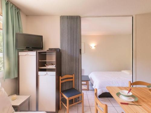 Cette petite chambre comprend un lit et une table avec une chaise. dans l'établissement Appartement 2 pièces avec coin nuit, balcon, parking et casier à ski - Proche télécabine et centre - FR-1-330C-16, à Briançon