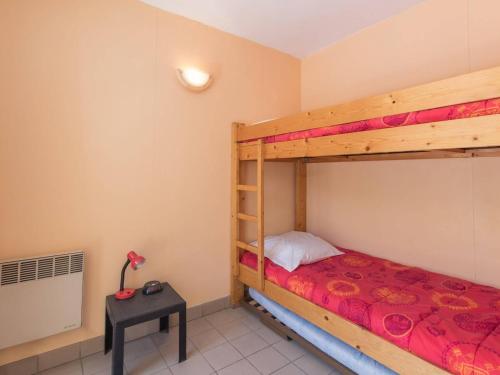 une chambre avec deux lits superposés et une table dans l'établissement Studio cosy avec balcon proche télécabine et centre ville, parking, animaux admis - FR-1-330C-49, à Briançon