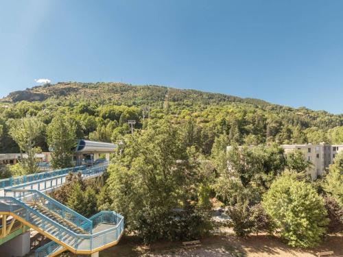 un escalier menant à un bâtiment avec une colline en arrière-plan dans l'établissement Studio cosy avec balcon proche télécabine et centre ville, parking, animaux admis - FR-1-330C-49, à Briançon