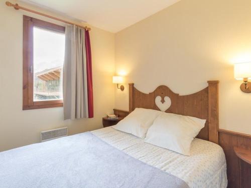 une chambre avec un lit avec une tête de lit en bois et une fenêtre dans l'établissement Charmant 2 pièces au cœur de La Salle-les-Alpes, proche télécabines et commerces, 4 couchages - FR-1-330F-45, à Serre Chevalier