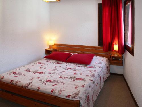 - une chambre avec un lit et 2 oreillers rouges dans l'établissement Appartement Les Orres, 2 pièces, 6 personnes - FR-1-322-305, aux Orres