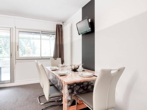 une salle à manger avec une table, des chaises et une télévision dans l'établissement Studio moderne 6 pers avec terrasse au pied des pistes - FR-1-400-10, à Gourette