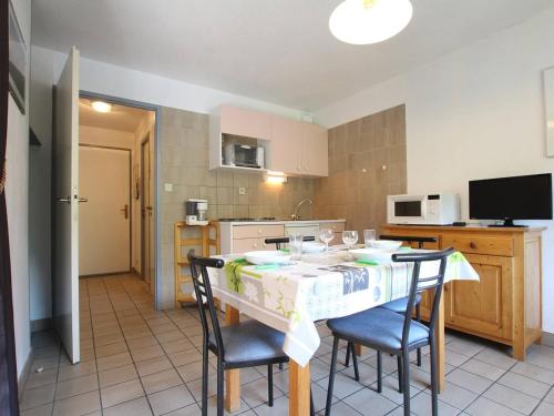 a kitchen with a table and chairs and a kitchen with a tv at Appartement Briançon, 1 pièce, 4 personnes - FR-1-330C-41 in Briançon