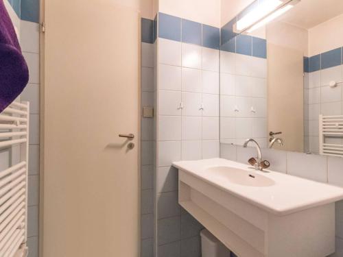 une salle de bain blanche avec un lavabo et un miroir dans l'établissement Studio cosy avec balcon, proche des pistes et du centre de Briançon, pour 2-4 personnes - FR-1-330C-41, à Briançon
