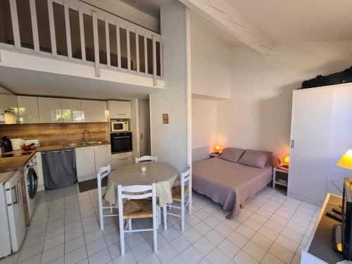 une cuisine et une chambre avec un lit et une table dans l'établissement Pavillon Studio Mezzanine 4 Pers avec Piscine, Terrasse et Parking à Argelès-sur-Mer - FR-1-388-91, à Argelès-sur-Mer