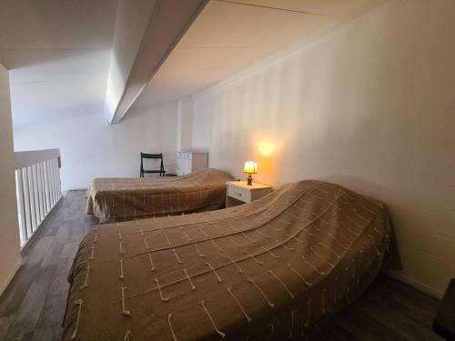 une chambre avec deux lits et une table avec une lampe dans l'établissement Pavillon Studio Mezzanine 4 Pers avec Piscine, Terrasse et Parking à Argelès-sur-Mer - FR-1-388-91, à Argelès-sur-Mer
