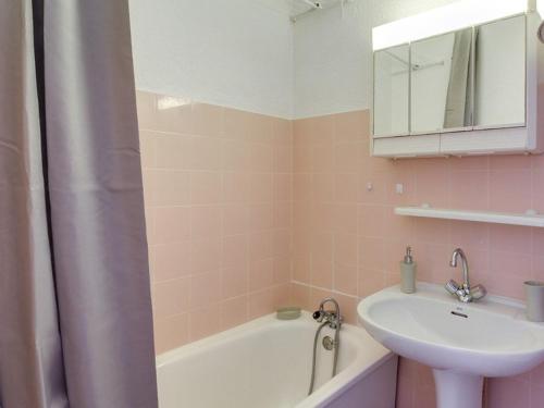 uma casa de banho rosa com um lavatório e uma banheira em Studio La Mongie, 1 pièce, 4 personnes - FR-1-404-100 em La Mongie