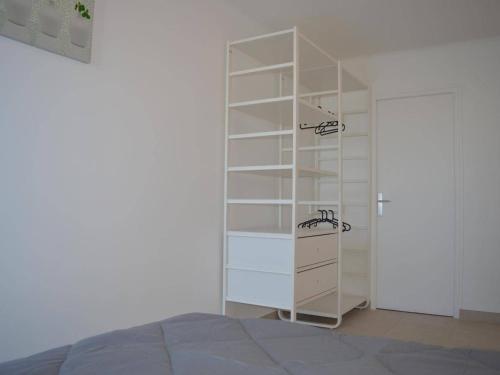 - une chambre avec une étagère blanche à côté d'un lit dans l'établissement Appartement rénové 4 pers avec terrasse et WIFI - Banyuls - FR-1-225C-34, à Banyuls-sur-Mer