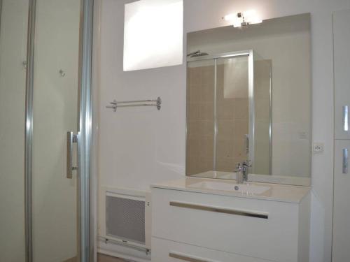 une salle de bain blanche avec un lavabo et un miroir dans l'établissement Appartement rénové 4 pers avec terrasse et WIFI - Banyuls - FR-1-225C-34, à Banyuls-sur-Mer