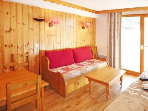 - une chambre avec un lit doté d'oreillers rouges et d'une table dans l'établissement Appartement cosy avec WiFi gratuit, piscine chauffée, sauna, et accès direct aux pistes, Les Orres 1800. - FR-1-322-302, aux Orres