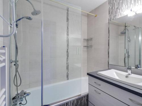 Un baño con ducha de cristal y lavabo. en Duplex 8 pers. à La Mongie, balcon, vue montagnes, proche pistes - FR-1-404-110, en La Mongie