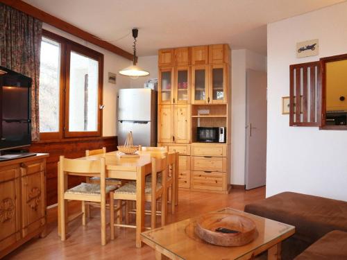 un salon avec une table et une cuisine dans l'établissement Appartement confort 2P, 6 pers, cœur de station, accès direct pistes, cheminée, WiFi, TV, balcon ouest - FR-1-322-297, aux Orres