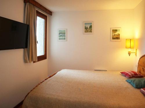 a bedroom with a bed with a television on the wall at Appartement Les Orres, 2 pièces, 6 personnes - FR-1-322-297 in Les Orres