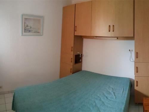 - une chambre avec un lit vert et des placards en bois dans l'établissement Argelès-sur-Mer, T2 + Cabine, 6 pers., plage à 100m, parking, ascenseur - FR-1-388-19, à Argelès-sur-Mer