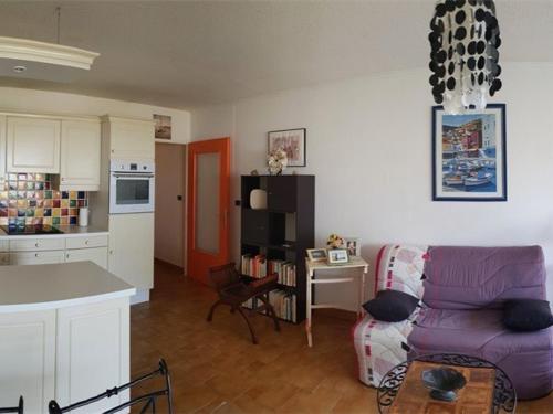 a living room with a purple couch and a kitchen at Appartement Argelès-sur-Mer, 2 pièces, 4 personnes - FR-1-388-31 in Argelès-sur-Mer