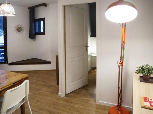 une chambre avec une porte, une table et une lampe dans l'établissement Studio cosy 4 pers, skis aux pieds, balcon Sud, centre station - FR-1-322-304, aux Orres