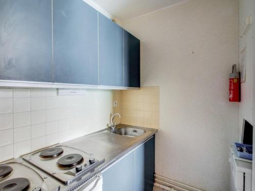 une petite cuisine avec un évier et une cuisinière dans l'établissement Studio cabine 6 personnes avec balcon à La Mongie, près des pistes - FR-1-404-72, à La Mongie