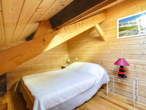 une chambre avec un lit dans une pièce en bois dans l'établissement Duplex cosy 4 pers au centre de Cauterets, proche télécabine, skis et commerces - FR-1-401-27, à Cauterets
