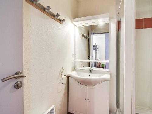 une salle de bain blanche avec un lavabo et un miroir dans l'établissement Appartement T2 avec coin nuit, face télécabine, 4 pers, plein centre, Cauterets - FR-1-401-7, à Cauterets