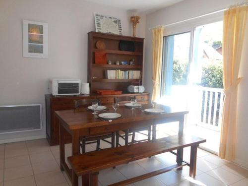 - un salon avec une table en bois et une fenêtre dans l'établissement Duplex 3 pièces avec balcon, parking et proximité télécabine à Cauterets - FR-1-401-50, à Cauterets