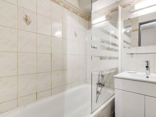 Un baño blanco con bañera y lavabo. en Studio cabine 6 pers, idéal montagne, ascenseur, ski, parking, animaux admis - FR-1-403-12, en Barèges