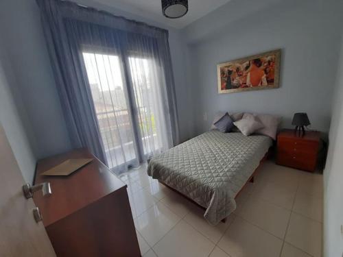 a bedroom with a bed and a desk and a window at Two bedroom modern apartment in Komotini