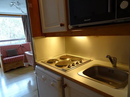 Il comprend une cuisine équipée d'une cuisinière. four supérieur à côté d'un évier dans l'établissement Studio pour 4 pers., skis aux pieds, proche commerces - FR-1-411-65, à Arc 1800