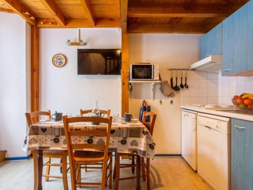 une cuisine avec une table et des chaises dans une cuisine dans l'établissement Appartement cosy 4 pers avec parking, terrasse, local à skis - FR-1-403-21, à Barèges