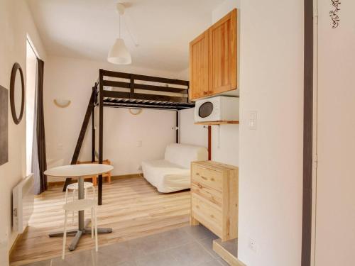 コトレにあるAppartement Cauterets, 3 pièces, 6 personnes - FR-1-401-33の二段ベッドとテーブルが備わる小さな客室です。