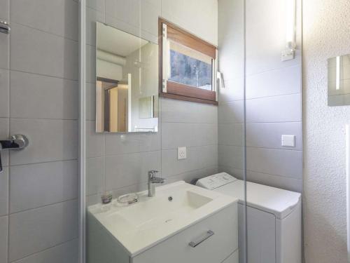 une salle de bain blanche avec un lavabo et un miroir dans l'établissement Appartement cosy à Cauterets, 4 pers, 1 ch, balcon, proche télécabine et centre - FR-1-401-41, à Cauterets
