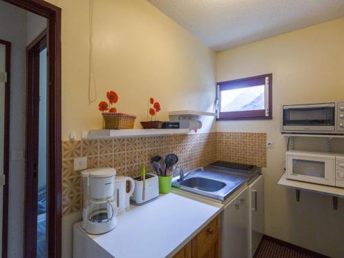 une petite cuisine avec un évier et un micro-ondes dans l'établissement Appartement cosy à Cauterets, 4 pers, 1 ch, balcon, proche télécabine et centre - FR-1-401-41, à Cauterets