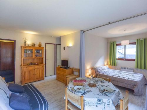- un salon avec un lit et une table dans l'établissement Appartement cosy à Cauterets, 4 pers, 1 ch, balcon, proche télécabine et centre - FR-1-401-41, à Cauterets