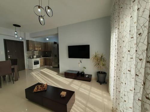 a living room with a couch and a tv on a wall at Two bedroom modern apartment in Komotini