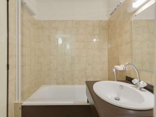a bathroom with a bath tub and a sink at Studio Gourette, 1 pièce, 4 personnes - FR-1-400-49 in Gourette